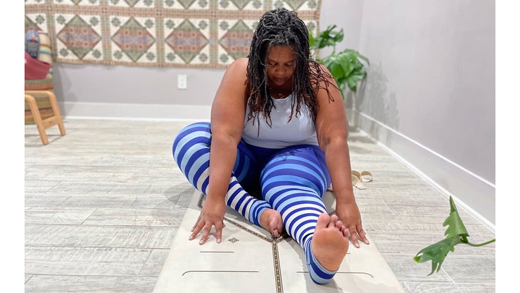 A person demonstrates Janu Sirsasana (Head-to-Knee Pose) in yoga