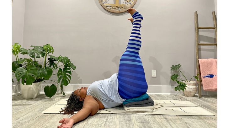 A person demonstrates Viparita Karani (Legs-Up-the-Wall Pose) in yoga
