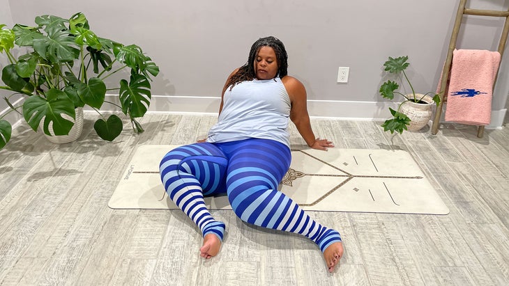 A person practices windshield-wiper twists in yoga