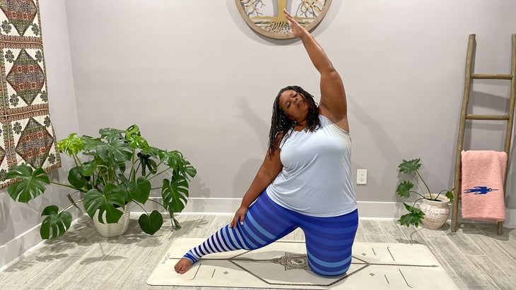 A person practices Parighasana (Gate Pose) with a side bend in yoga