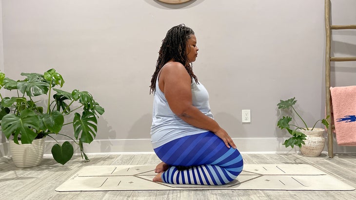 A person demonstrates Vajrasana (Thunderbolt Pose) in yoga