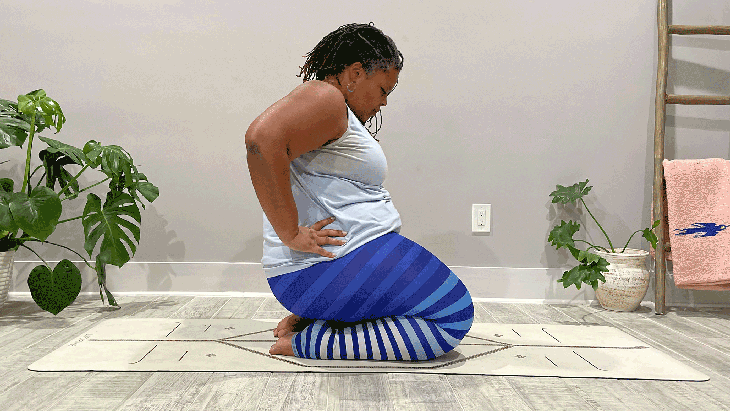 A person moves through a seated variation of Cat-Cow in yoga