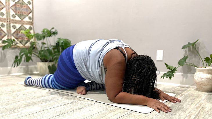A person demonstrates Half Pigeon Pose in yoga