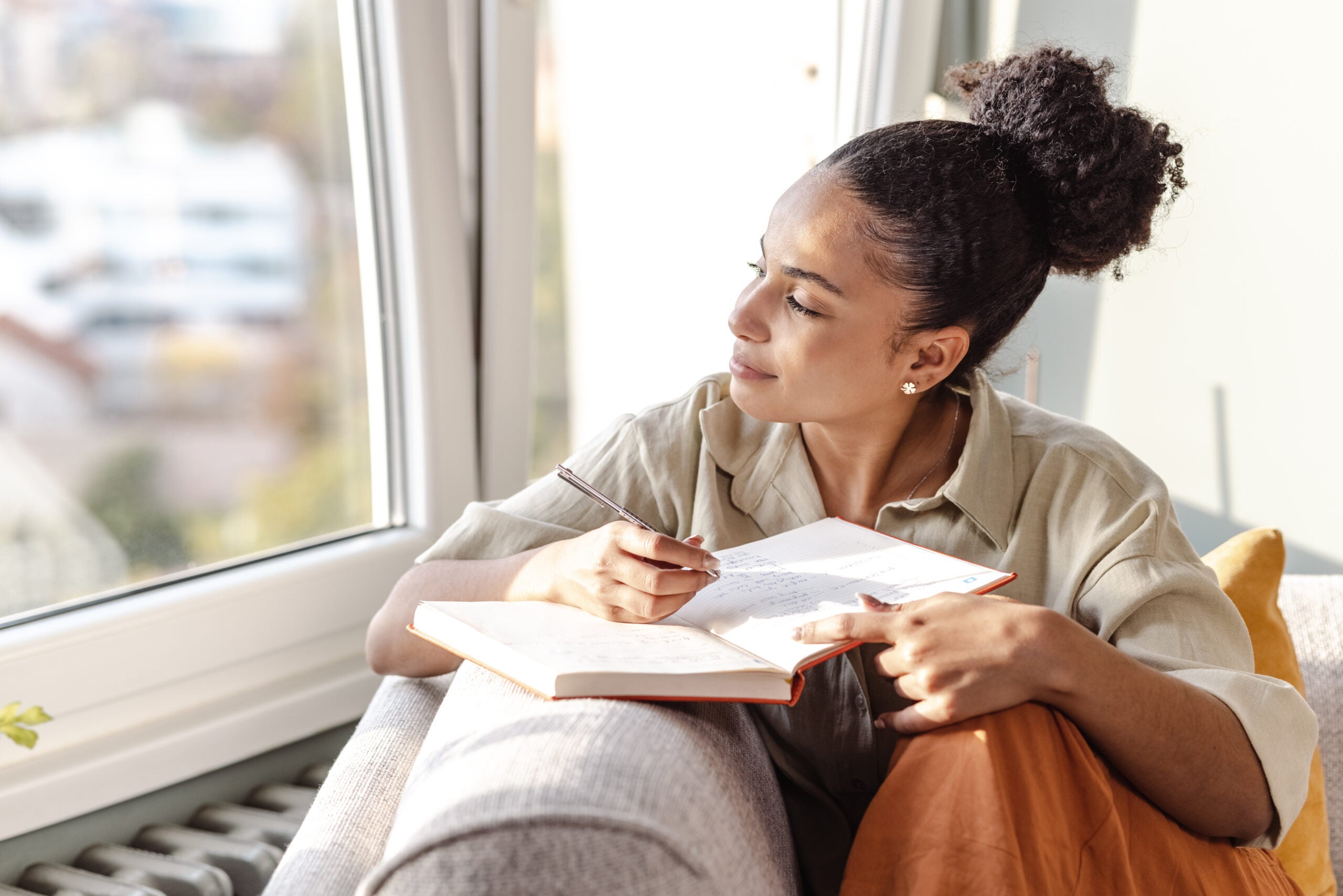 Woman manifesting by writing in her journal.