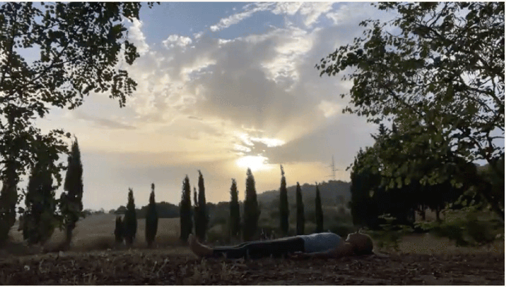 Woman lying on her back in Savasana after practicing sunrise yoga outside