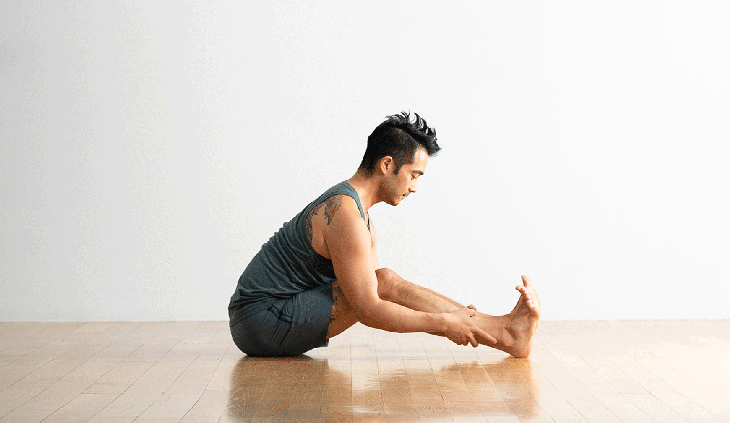 Man sitting and stretching tight hamstrings and low back