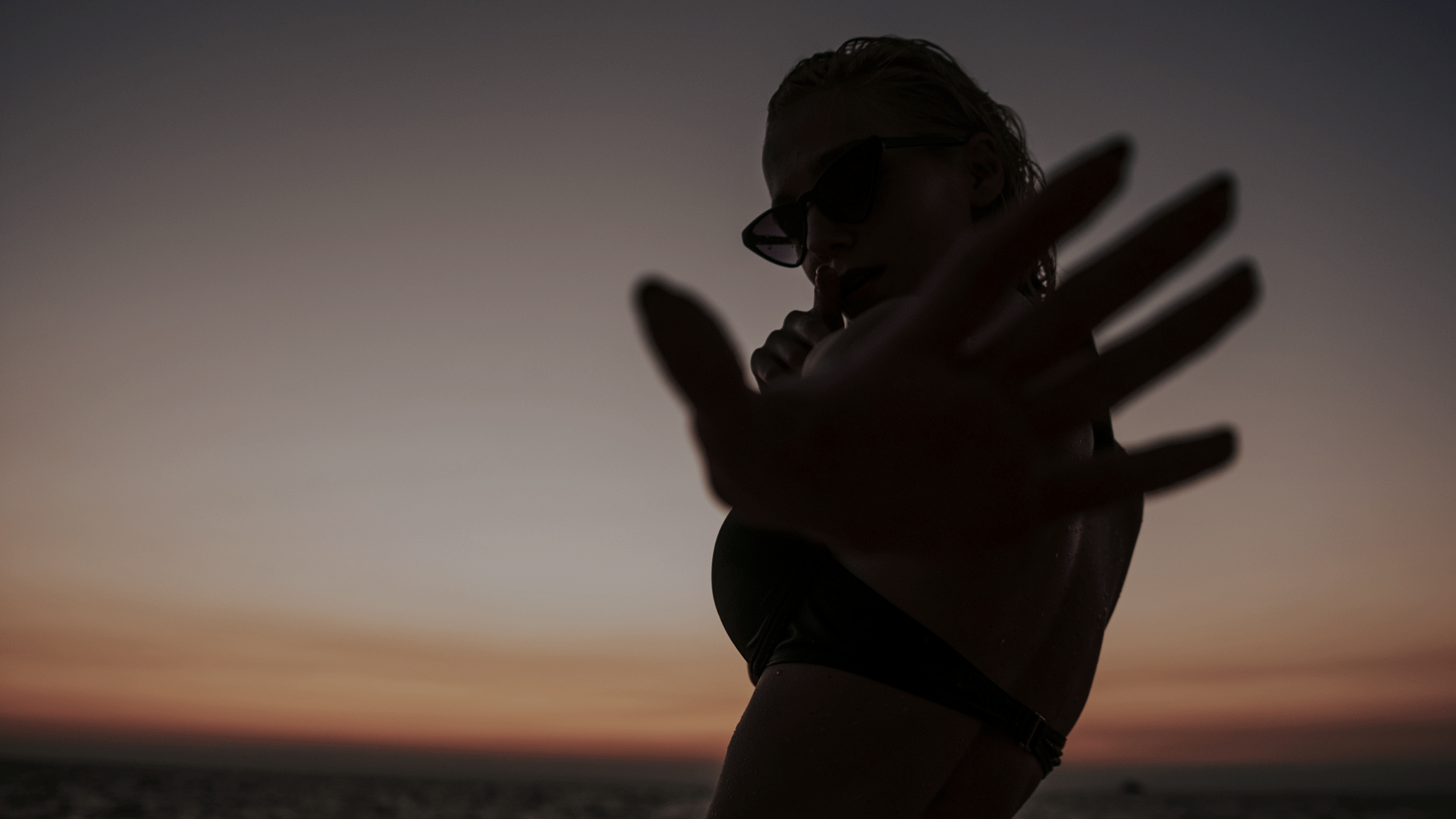 Woman standing outside at night holding her hand out