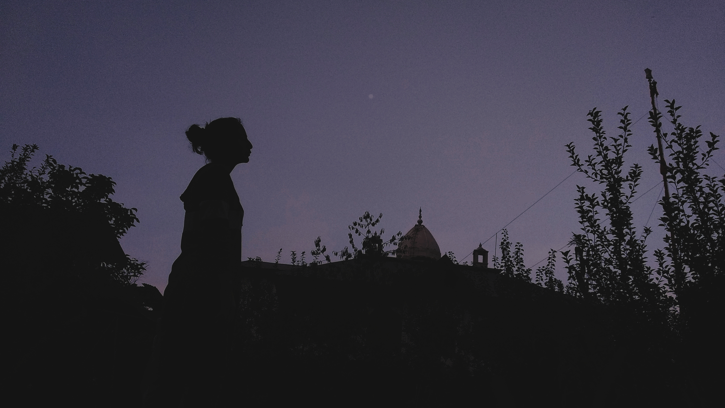 Woman standing outside beneath the full Moon