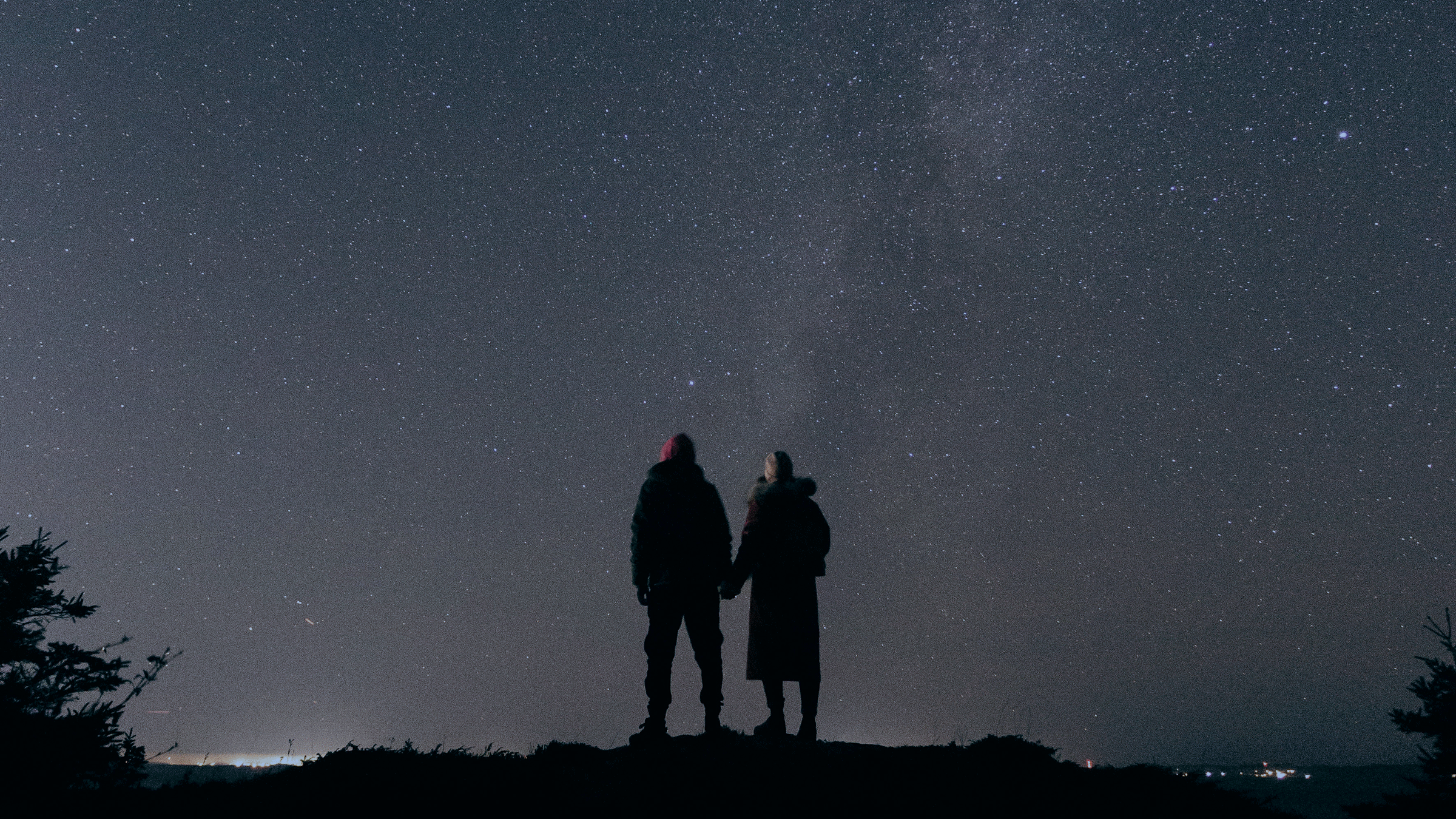 Couple outside at night in April watching the Lyra constellation and Lyrid meteor shower