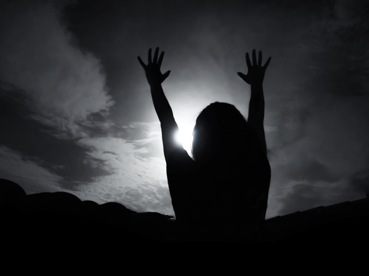 Woman standing outside beneath the full Moon in Sagittarius in June 2023 with her arms outstretched