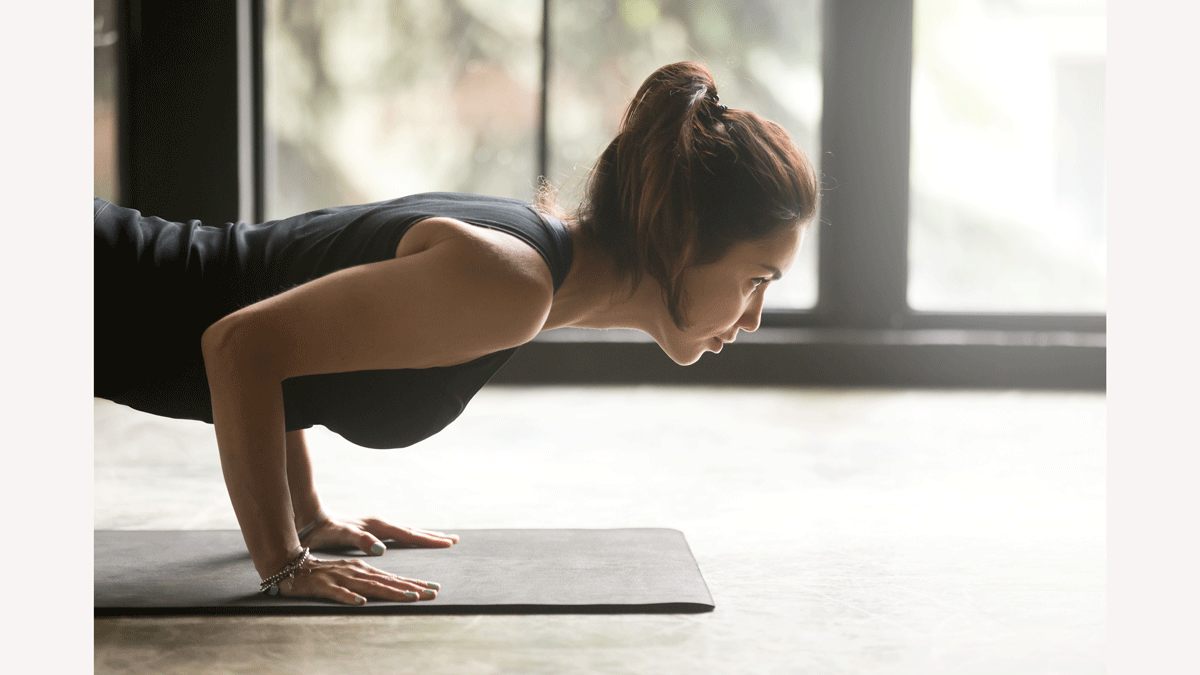 Woman on a yoga mat practicing Chaturanga