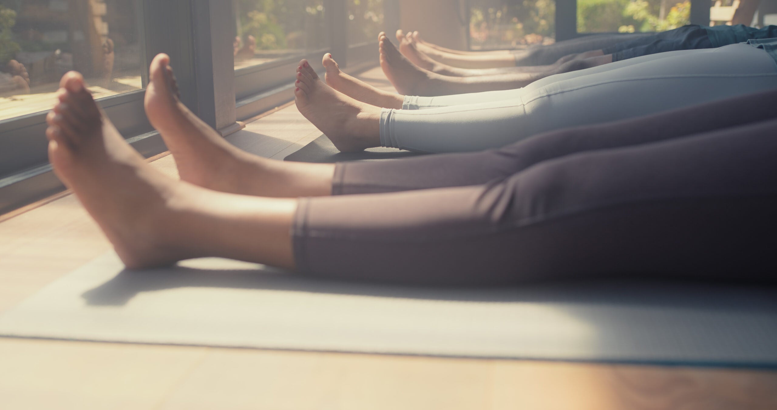 Savasana at the end of yoga class with legs on yoga mats