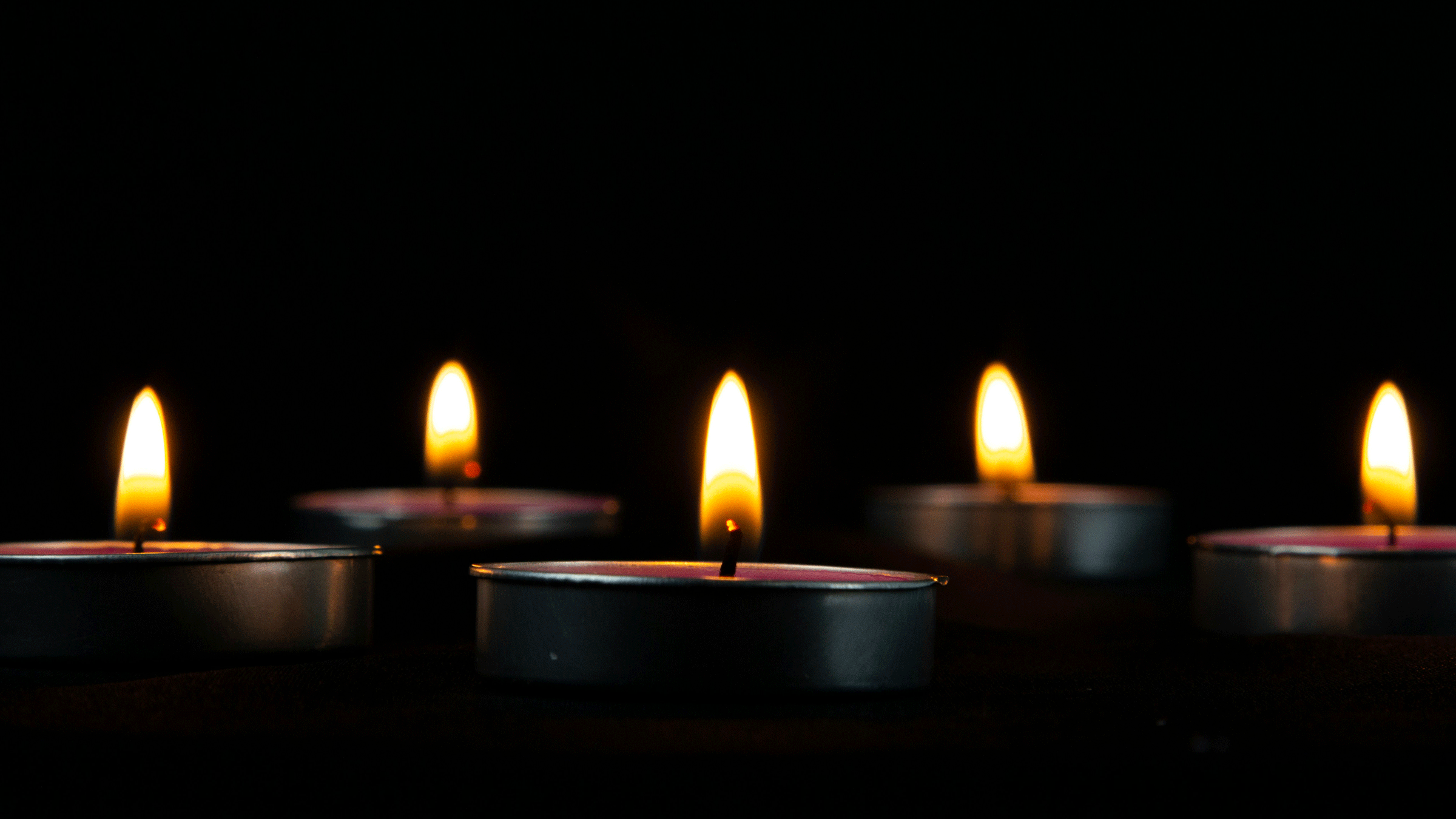 Lit candle tealights in the dark