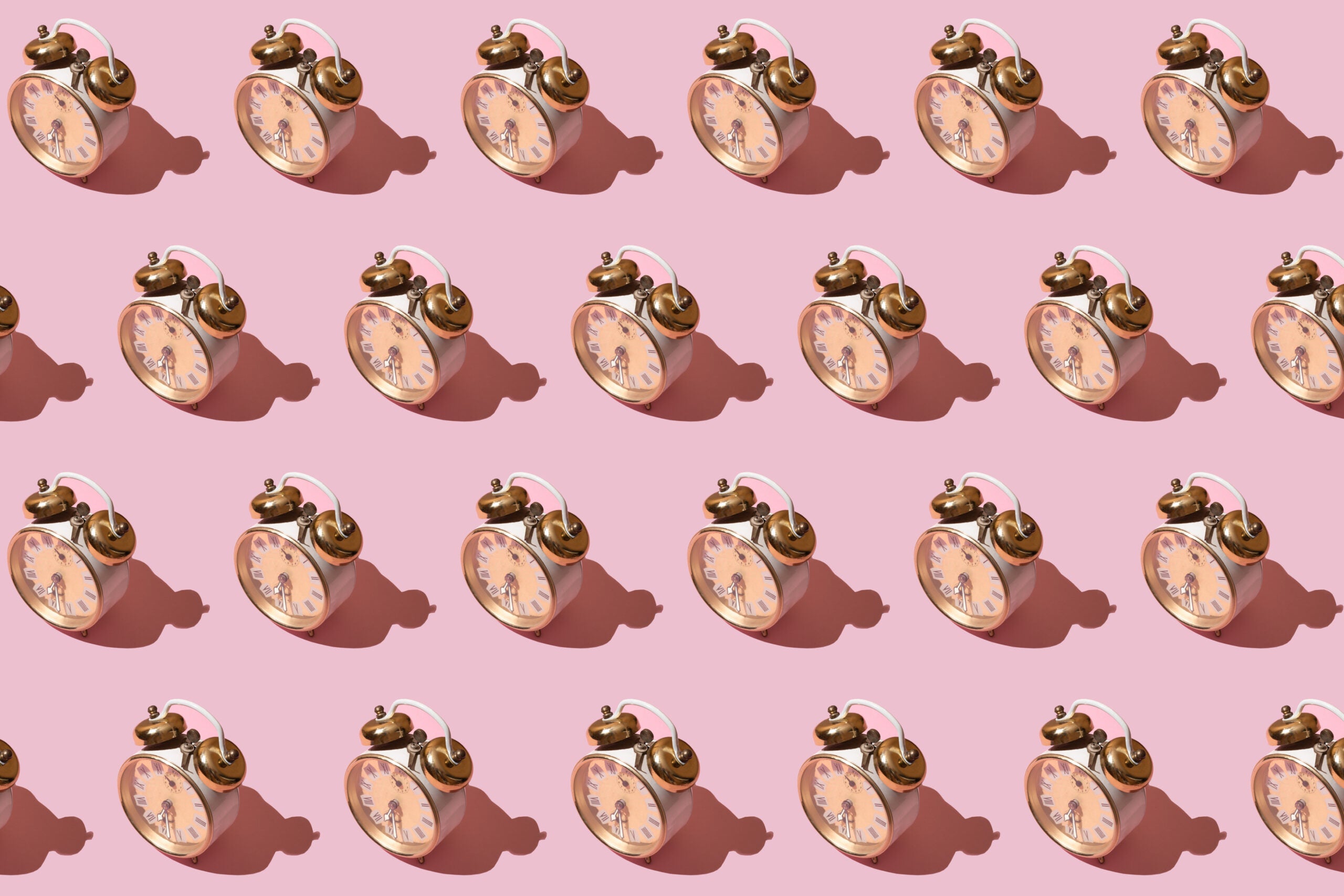 Image of old-fashioned clocks on pink background