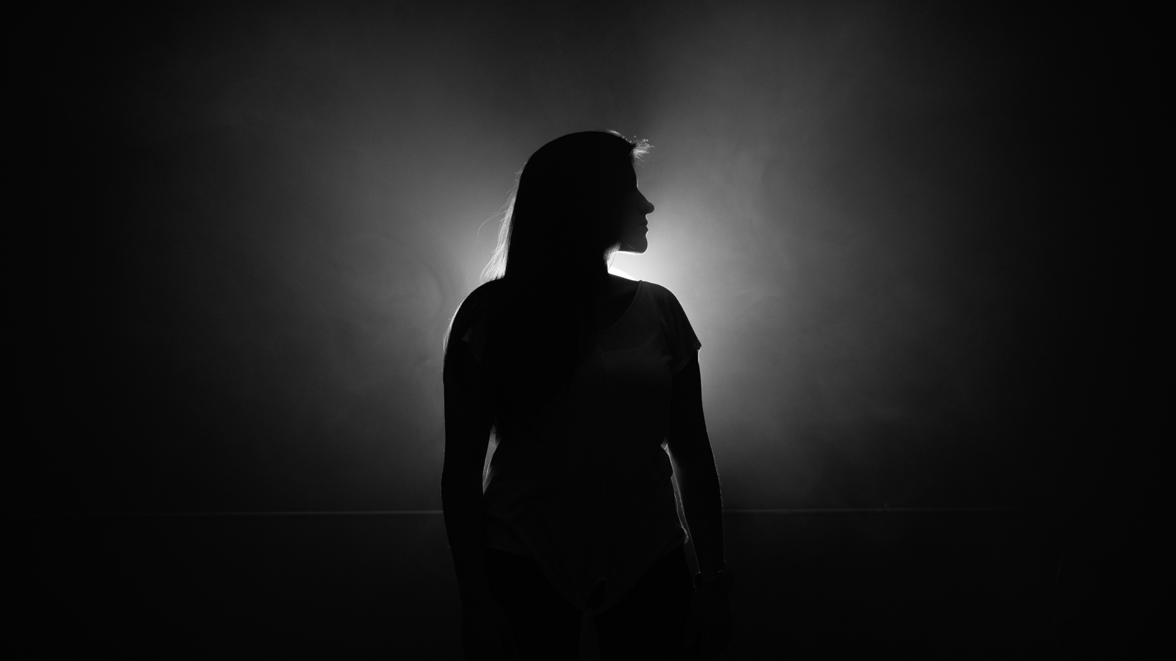 Woman standing outside in the dark of night in front of the full Moon in Sagittarius