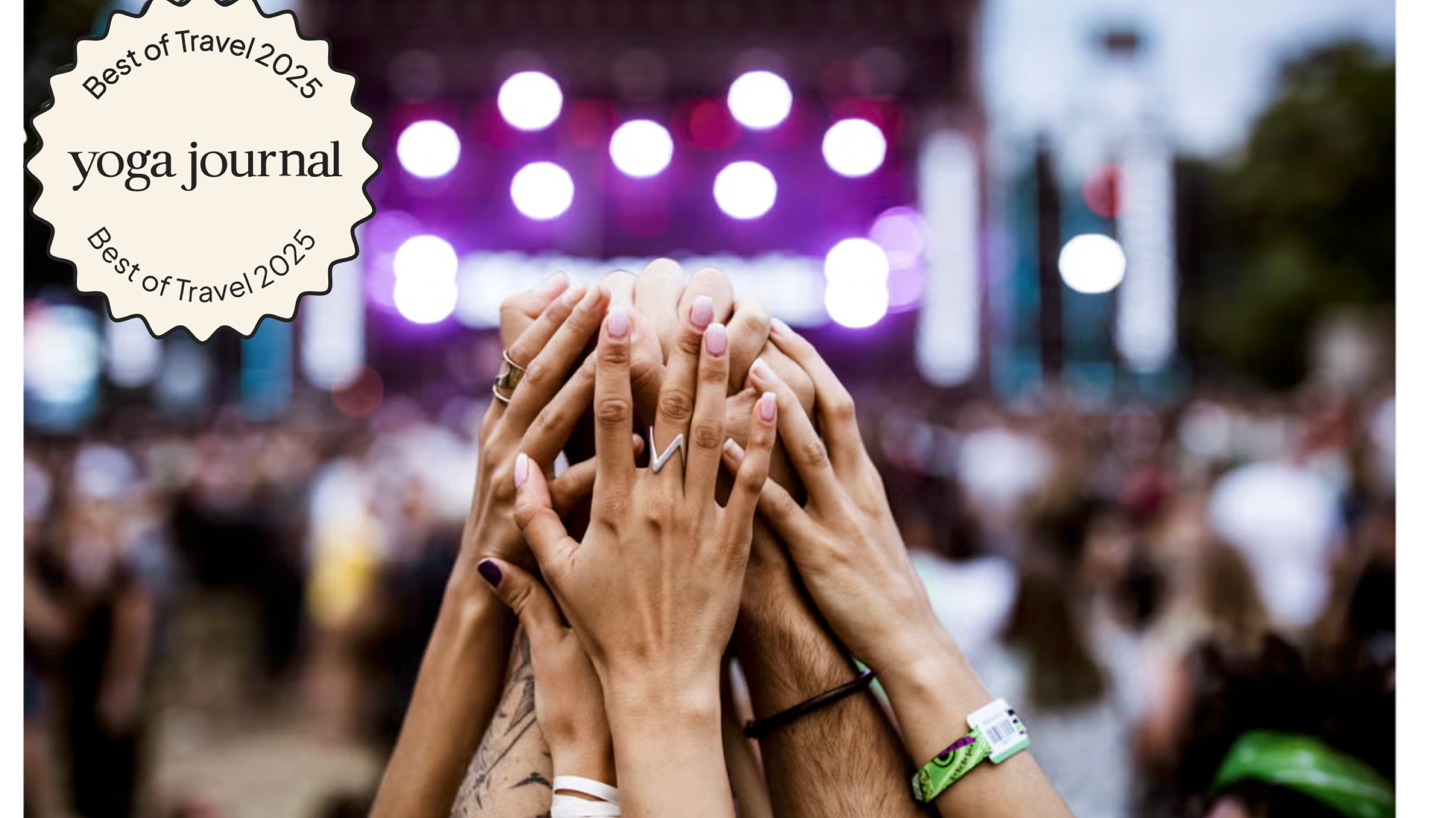 Several hands reaching together at a music concert taking place at a yoga festival