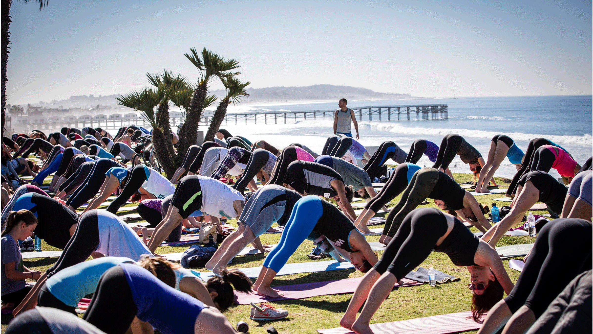 Yoga teacher Steve Hubbard leading class on the beach in San Diego