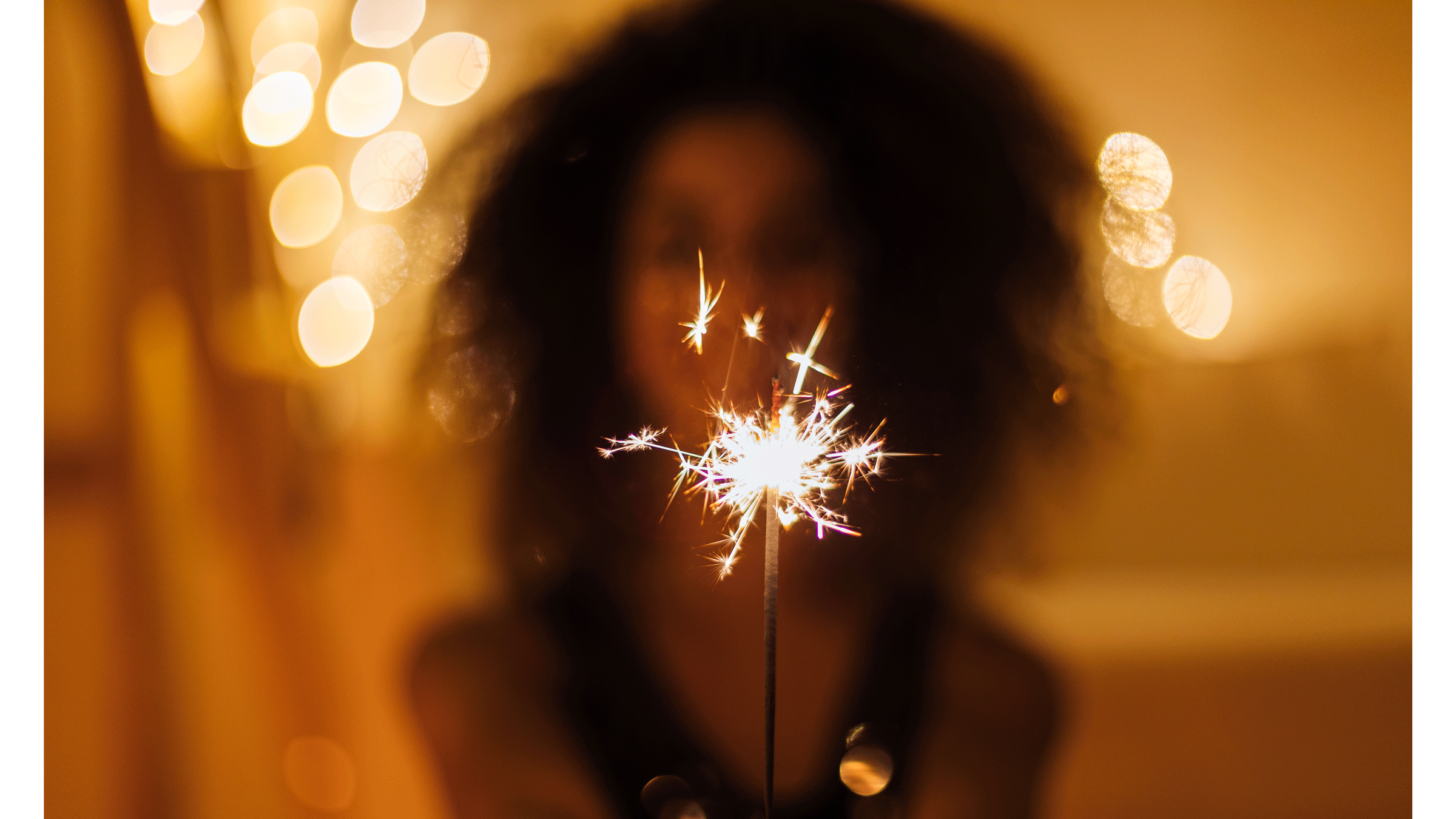 Woman holding a sparkler in front of her representing the new Moon in Leo during August 2024 and the self-awareness it brings.