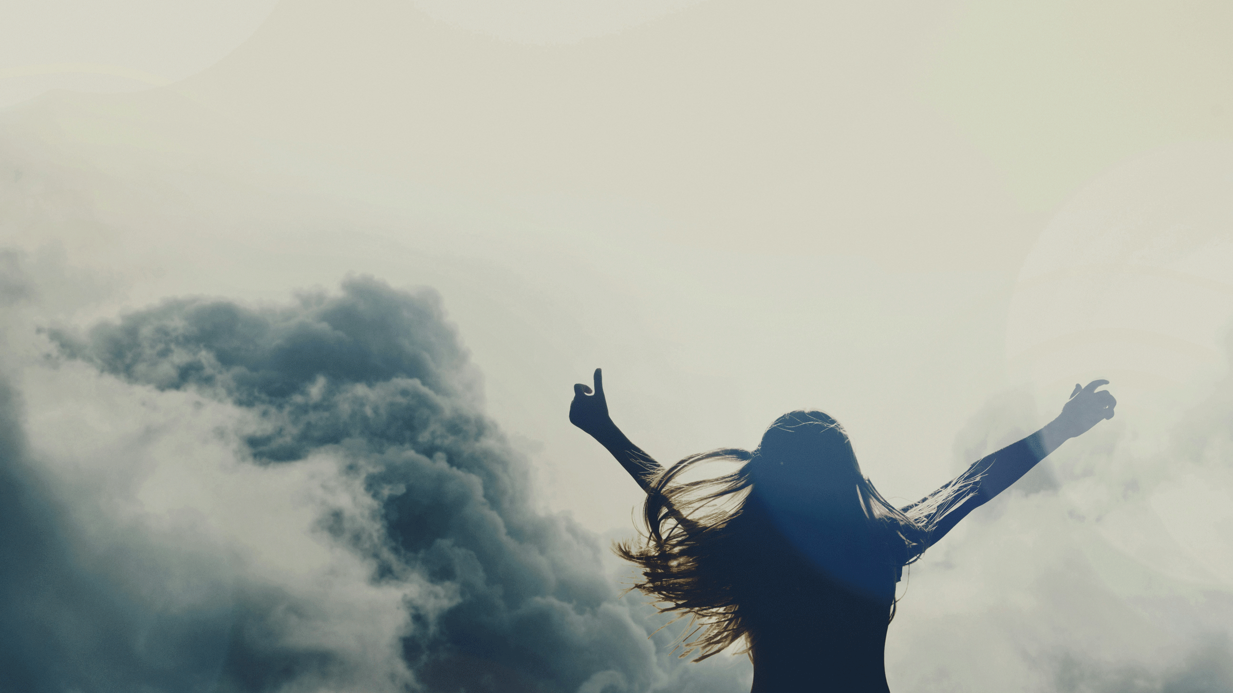 Woman standing outside on a cloudy day considering the astrology 2025.