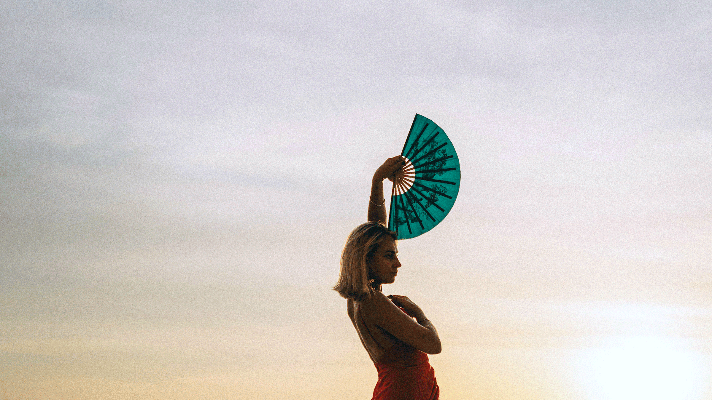 Woman standing outside at dusk dancing