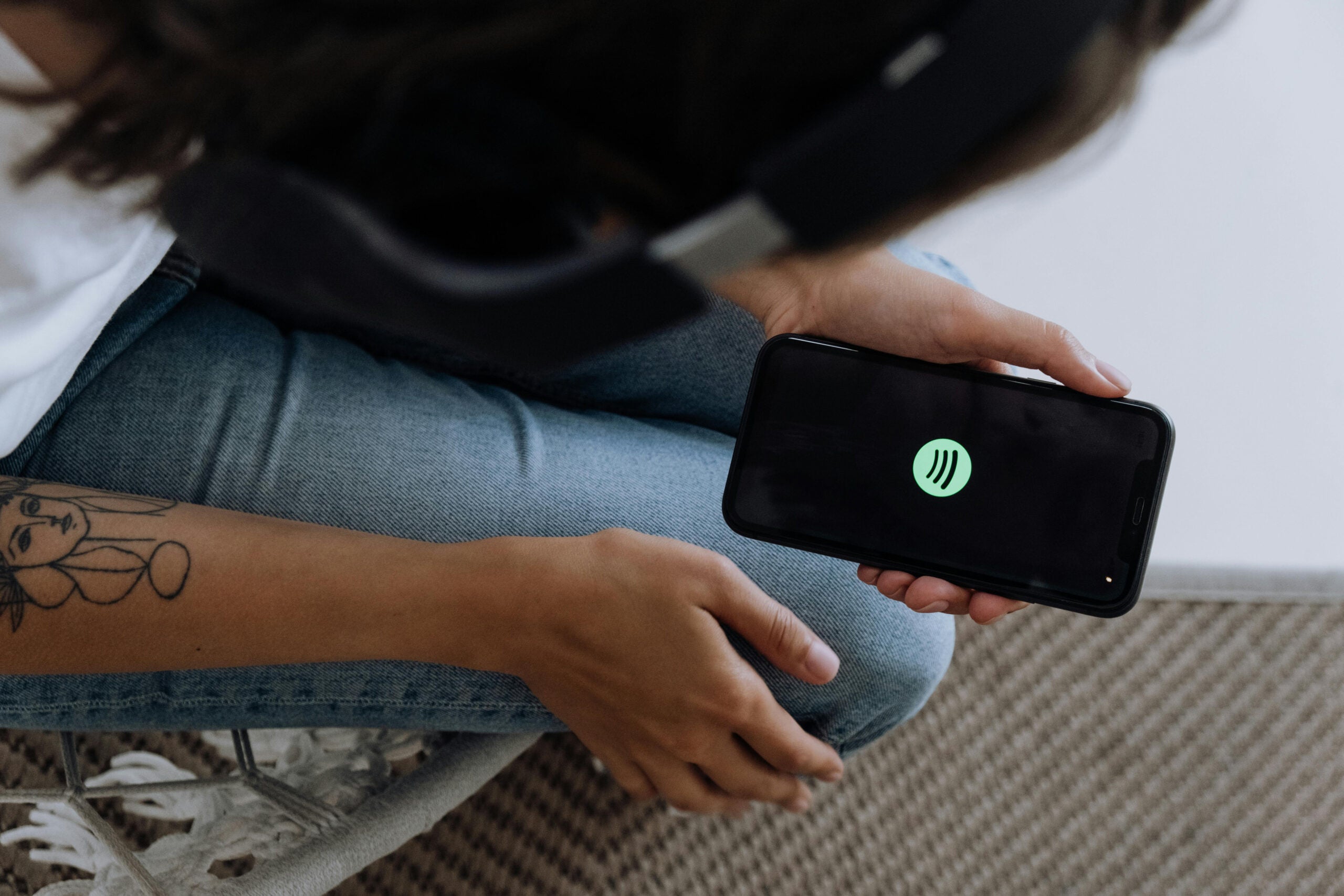 Woman opening Spotify on her phone.