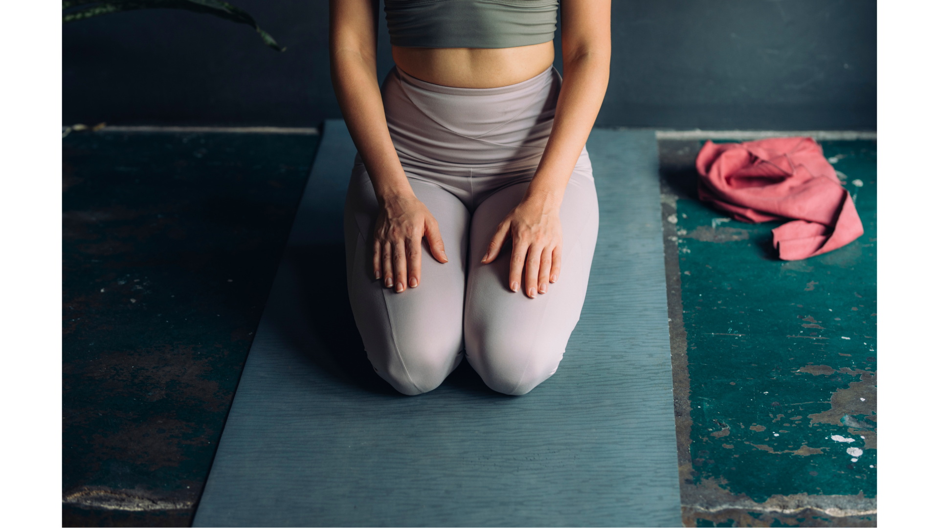 Yoga teacher kneeling on a mat