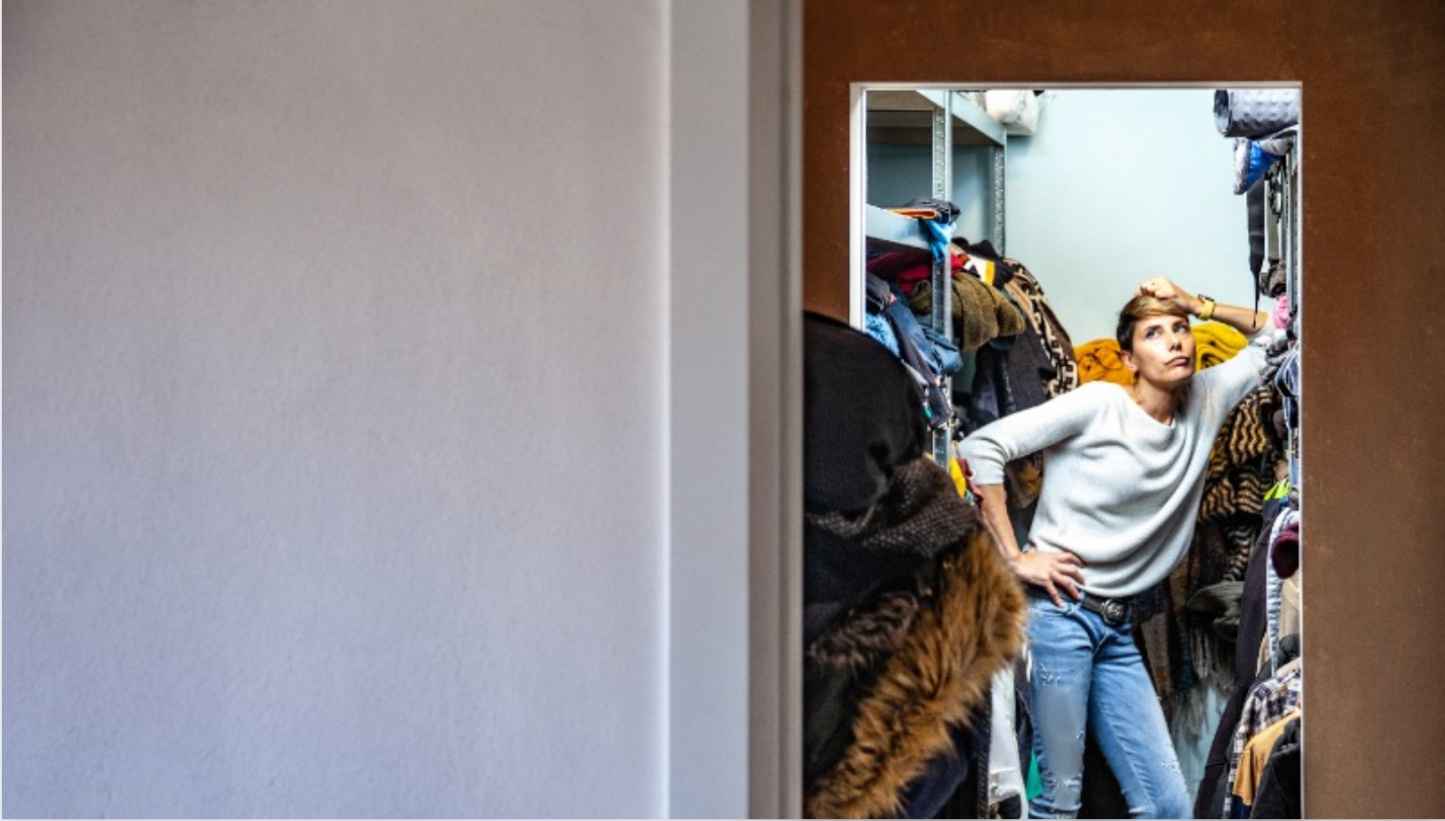 Woman standing in her closet considering reselling clothes