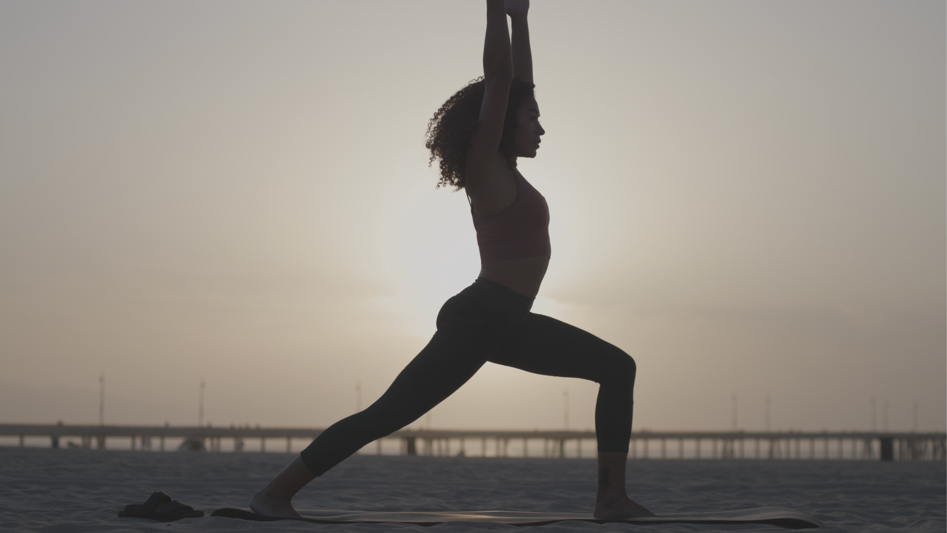 Woman standing outside in a high lunge during a 15-minute morning yoga session
