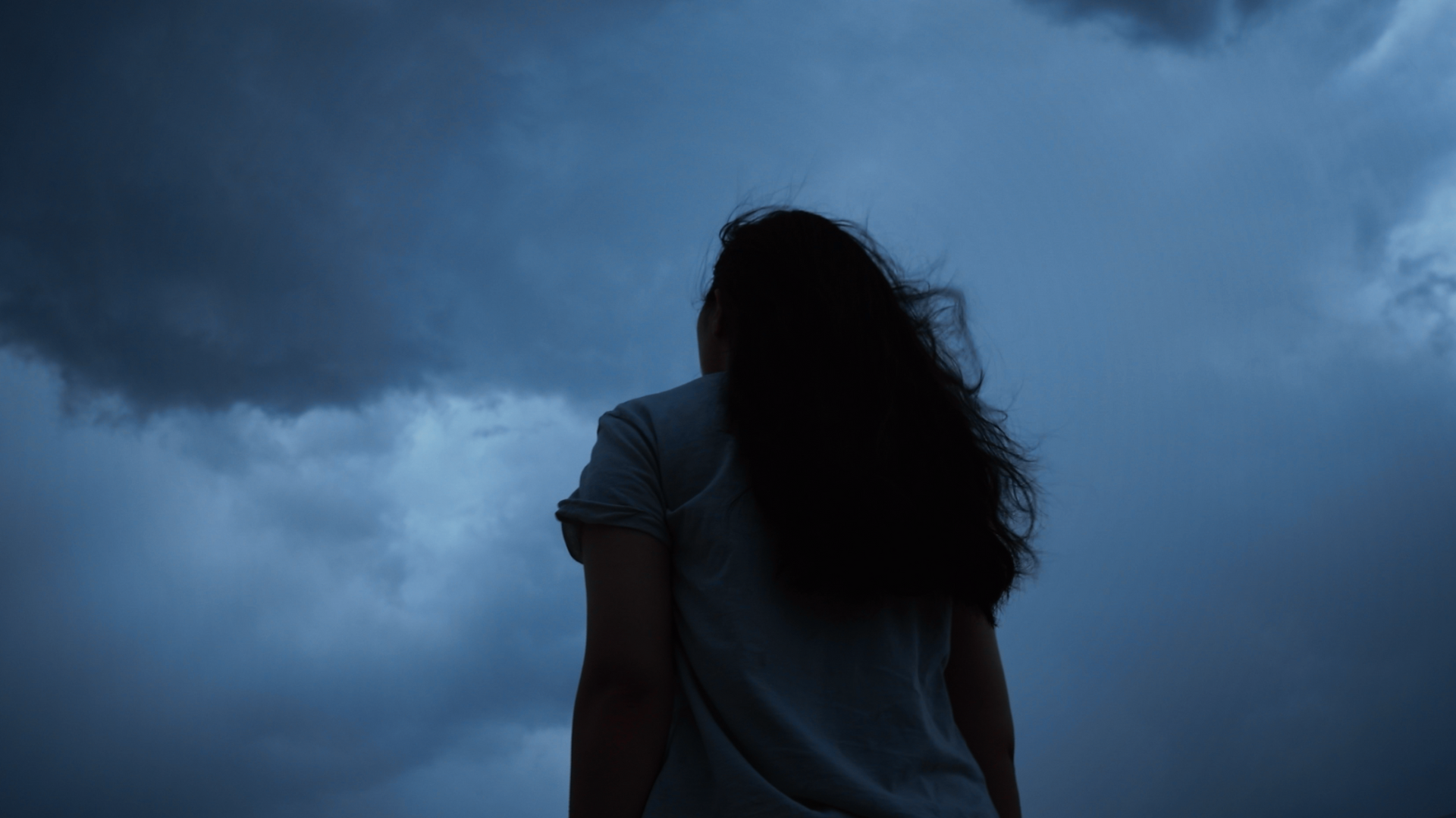 Woman standing outside at night during the new Moon in Gemini