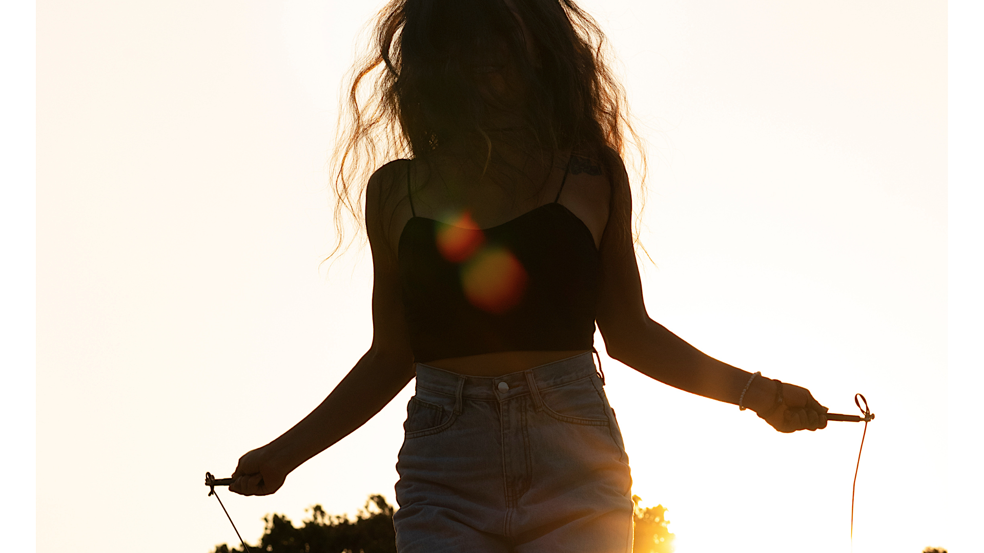 Woman jumping rope outside in the Sun while considering her weekly horoscope for July 20-26, 2025.