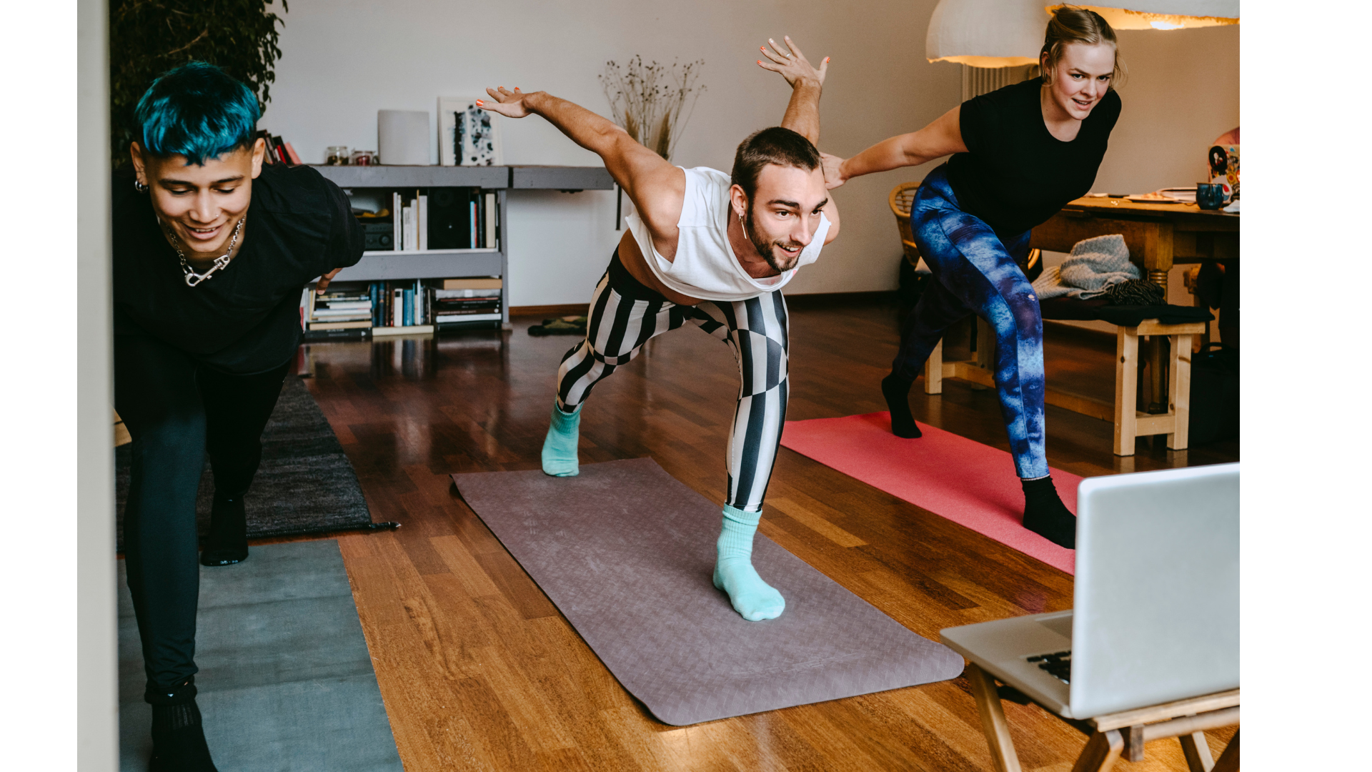 Three twentysomethings practicing yoga in a living room to Yoga Journal videos